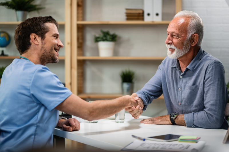 happy-doctor-greeting-handshaking-with-senior-patient-his-office-focus-is-senior-man